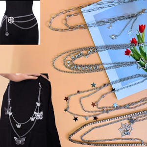 May include: Silver-toned chain belts with various charms, including stars, butterflies, and a pentagram. The belts are displayed on a neutral background, showcasing their intricate designs and multiple layers. The belts are designed to be worn around the waist.