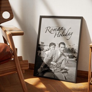 Może przedstawiać: Czarno-biały plakat filmu "Rzymskie wakacje" z Audrey Hepburn i Gregorym Peckiem jadącymi skuterem w Rzymie.