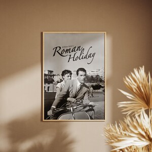 Może przedstawiać: Czarno-biały plakat filmu "Rzymskie wakacje" z Audrey Hepburn i Gregorym Peckiem jadącymi skuterem w Rzymie.