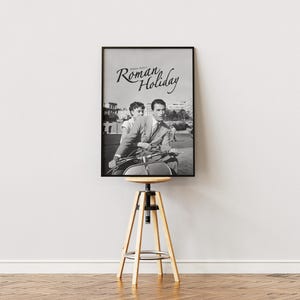 Może przedstawiać: Czarno-biały plakat filmu zatytułowanego "Rzymskie wakacje" przedstawiający mężczyznę i kobietę na skuterze.