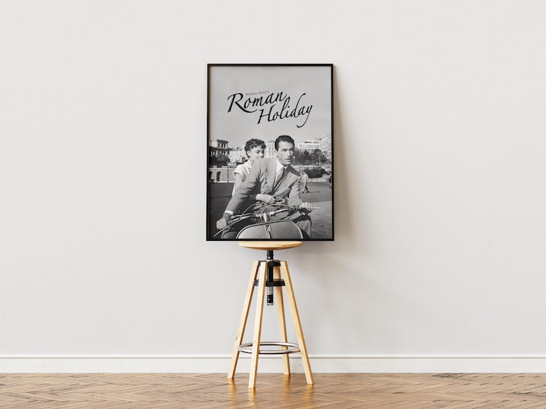 Może przedstawiać: Czarno-biały plakat filmu zatytułowanego "Rzymskie wakacje" przedstawiający mężczyznę i kobietę na skuterze.