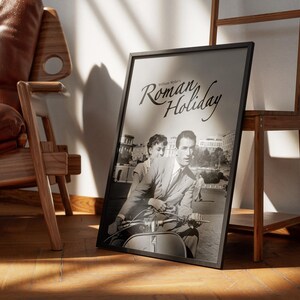 Może przedstawiać: Czarno-biały plakat z tytułem "Roman Holiday" przedstawiający mężczyznę i kobietę jadących skuterem przed budynkiem.