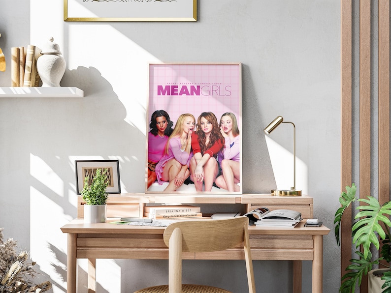 May include: A poster of the movie Mean Girls featuring four women in pink and red clothing. The poster has a pink background with the title "Mean Girls" in white text.