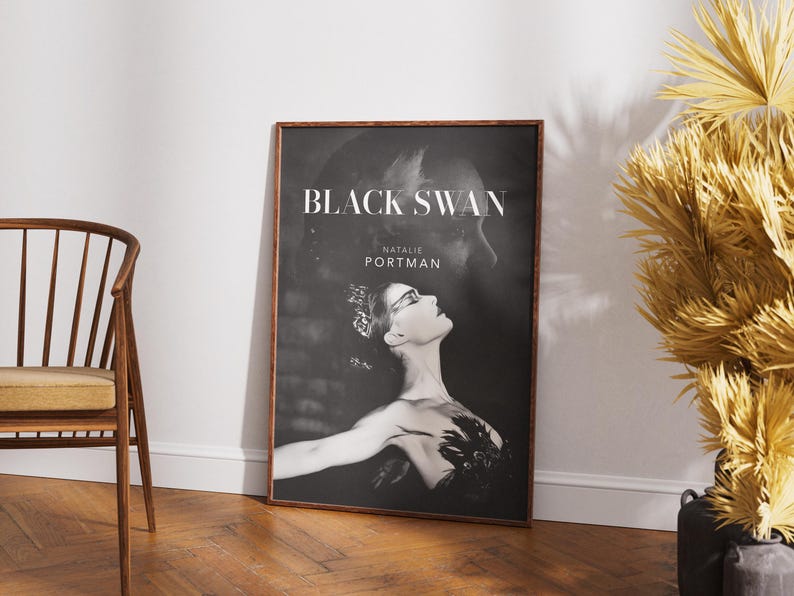 May include: Black and white movie poster for the film "Black Swan" starring Natalie Portman. The poster features a close-up of Portman as a ballerina in a black swan costume.
