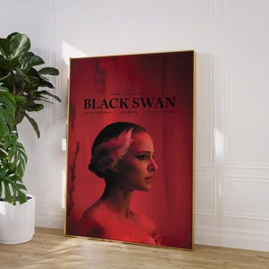 Puede incluir: Un p&oacute;ster de pel&iacute;cula para la pel&iacute;cula "Black Swan" con Natalie Portman con un vestido rojo y un tocado de plumas blancas. El p&oacute;ster tiene un fondo rojo con el t&iacute;tulo "Black Swan" en texto blanco.