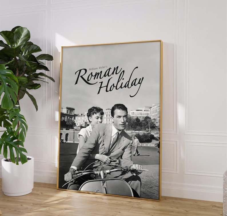 Może przedstawiać: Czarno-biały plakat filmowy do filmu "Rzymskie wakacje" z Audrey Hepburn i Gregorym Peckiem. Plakat przedstawia scenę, w kt&oacute;rej oboje aktorzy jadą skuterem po Rzymie.
