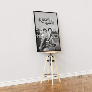 Może przedstawiać: Czarno-biały plakat filmu zatytułowanego "Rzymskie Wakacje" przedstawiający mężczyznę i kobietę na skuterze.