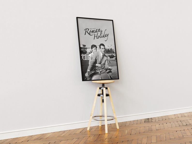 Może przedstawiać: Czarno-biały plakat filmu zatytułowanego "Rzymskie Wakacje" przedstawiający mężczyznę i kobietę na skuterze.