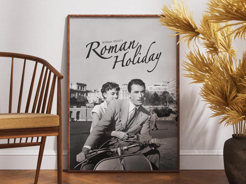 Może przedstawiać: Czarno-biały plakat z tytułem "Roman Holiday" napisanym kursywą. Plakat przedstawia scenę z filmu z mężczyzną i kobietą jadącymi na skuterze.