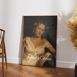 May include: A white ceramic mug with a black handle and the text "But First, Coffee" in a bold, black font. The mug is set against a plain white background, highlighting its simple design.