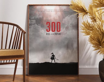 May include: Framed movie poster for "300: Rise of an Empire." The poster features the title in large red numbers, a silhouette of a warrior, and text indicating the director and source material. The poster is in a wooden frame.