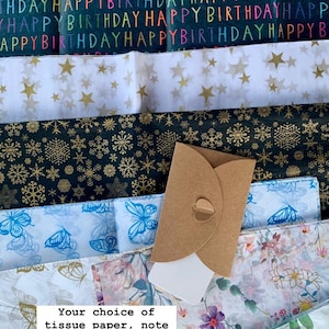 May include: Assortment of gift wrap options including tissue paper with hearts, stars, snowflakes, butterflies, and floral patterns.  A brown envelope is included.  The text reads "Your choice of tissue paper, note card & envelope, and ribbon. Only &pound;2."
