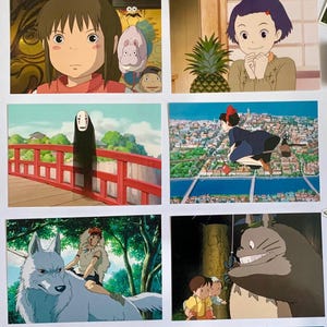 May include: A collection of nine postcards featuring characters and scenes from Studio Ghibli animated films. The postcards feature characters such as Totoro, Kiki, and No Face, as well as scenes from the films.