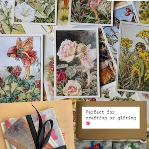 May include: A collection of vintage fairy postcards featuring illustrations of fairies in various garden settings. The postcards are packaged in a brown envelope with a black ribbon and a small heart sticker. The text "Perfect for crafting or gifting" is written on a brown paper tag.