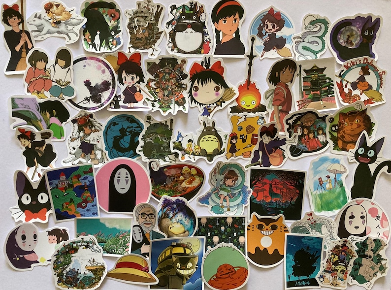 May include: A collection of colourful stickers featuring characters and scenes from popular Japanese animated films, including Totoro, Kiki's Delivery Service, and Spirited Away. The stickers are printed on white paper and have a glossy finish.