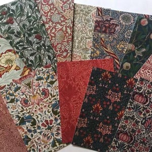 May include: A collection of 10 fabric swatches featuring various floral patterns in shades of red, green, and cream. The fabrics are arranged in a fan shape, showcasing the different designs.
