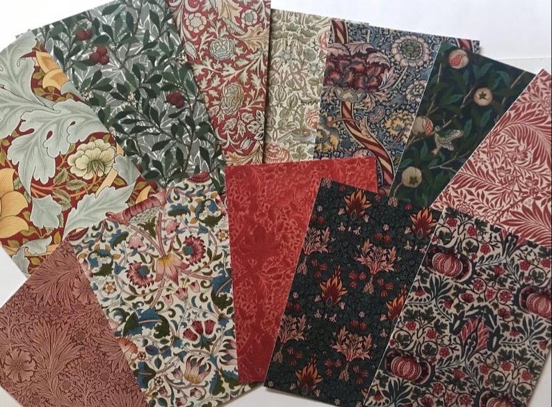 May include: A collection of 10 fabric swatches featuring various floral patterns in shades of red, green, and cream. The fabrics are arranged in a fan shape, showcasing the different designs.