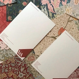 May include: Two white letterheads with the Victoria and Albert Museum logo and text. The letterheads are on top of a variety of patterned papers with floral designs in shades of red, blue, green, and brown.