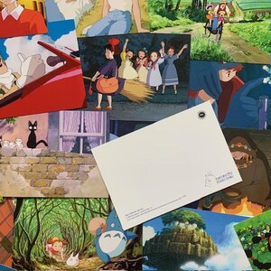 May include: A collection of colourful postcards featuring scenes from Studio Ghibli films, including Totoro, Kiki's Delivery Service, and Howl's Moving Castle.