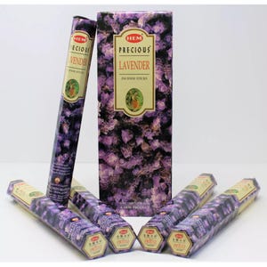 May include: A box of HEM Precious Lavender incense sticks. The box features a purple and black floral design with the HEM logo and product name. The box contains six incense sticks.