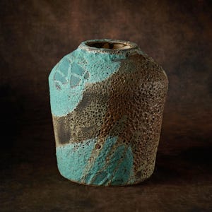 May include: A ceramic vase with a textured, mottled surface in shades of brown and teal.