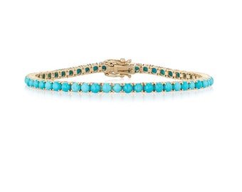 May include: A gold tennis bracelet with turquoise stones.
