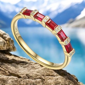 Könnte beinhalten: Ein Goldring mit fünf roten Rubin-Steinen und kleinen Diamanten, die zwischen jedem Stein eingefasst sind. Der Ring ist mit der Nummer "0-0451" graviert.