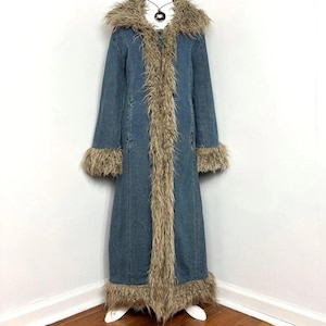 May include: A long blue denim coat featuring a large collar, long sleeves, and a full-length front opening trimmed with shaggy, light brown faux fur. The hem of the coat and the sleeve cuffs are also finished with matching faux fur trim.