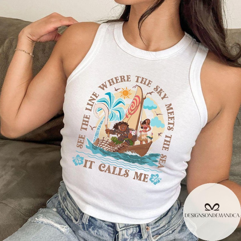 May include: White tank top with a colorful graphic featuring a boat with characters, palm trees, and the text "SEE THE LINE WHERE THE SKY MEETS THE SEA IT CALLS ME".