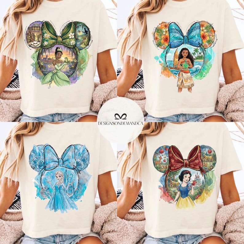 Puede incluir: Cuatro camisetas color crema con dise&ntilde;os de personajes de Disney dentro de siluetas de orejas de Mickey Mouse. Los dise&ntilde;os incluyen a Tiana, Moana, Elsa y Blancanieves. El texto "DESIGNSONDEMANDCA" es visible en un c&iacute;rculo blanco.
