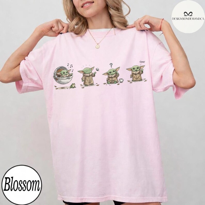 May include: A light pink t-shirt featuring a cartoon sequence of a character from a popular science fiction series. The character is depicted in various poses, with the word "Cool" printed on the shirt. The shirt has a round neckline and short sleeves.