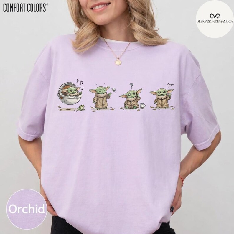 May include: A light purple t-shirt with a graphic of a character in various poses. The character is in a brown robe and has large ears. The shirt has the word "Orchid" printed on it. The shirt also has the words "Comfort Colors" printed on it.