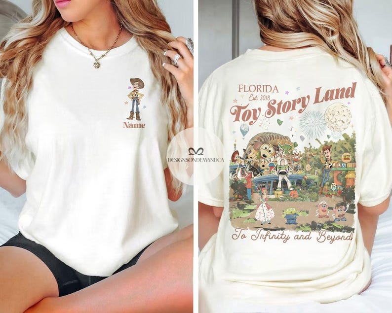 Puede incluir: Camiseta color crema con una imagen de dibujos animados de Woody de Toy Story en la parte delantera, con el campo de nombre debajo. La parte posterior de la camiseta muestra un gr&aacute;fico de Toy Story Land con el texto "FLORIDA Est. 2018 Toy Story Land To Infinity and Beyond."