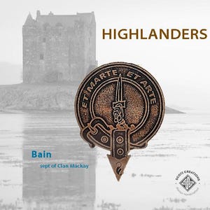 May include: A bronze-colored clan crest with the text "Et Marte Et Arte" and a dagger design. The crest is a sept of Clan Mackay, known as Bain.