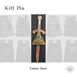 May include: A gold-colored kilt pin with a sword design and a blue and yellow trinity knot. The pin is displayed against a background of kilts.