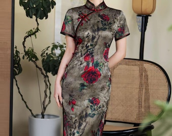 May include: A long, olive-green dress with a floral pattern of red roses and green leaves. The dress has short sleeves, a mandarin collar, and a side slit. The dress is a traditional Chinese cheongsam.