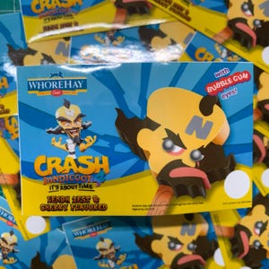 May include: A box of Crash Bandicoot-themed ice cream bars. The box is blue and yellow, featuring the character's face and the text "Crash Bandicoot 4: It's About Time." The ice cream is lemon zest and cherry flavored, with bubble gum eyes.