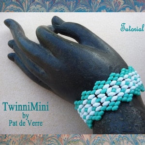 May include: A turquoise and white beaded bracelet with a chevron pattern. The bracelet is on a black hand model. The text "TwinniMini by Pat de Verre" is below the bracelet. The text "Tutorial" is in the top right corner of the image.