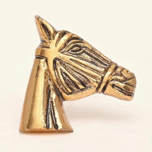 May include: A white ceramic mug with a black handle and the text "But First, Coffee" in a bold, black font. The mug is set against a neutral background, highlighting its simple design.