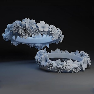 Puede incluir: Dos anillos grises impresos en 3D decorados con diseños florales. Los anillos están hechos para parecer coronas de flores.