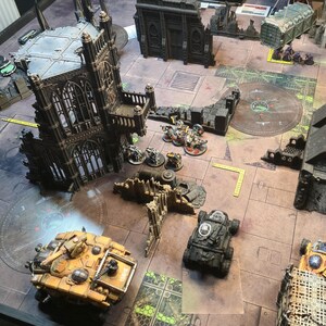 an aerial view of a Warhammer 40k game showing the deployment zone guides in use