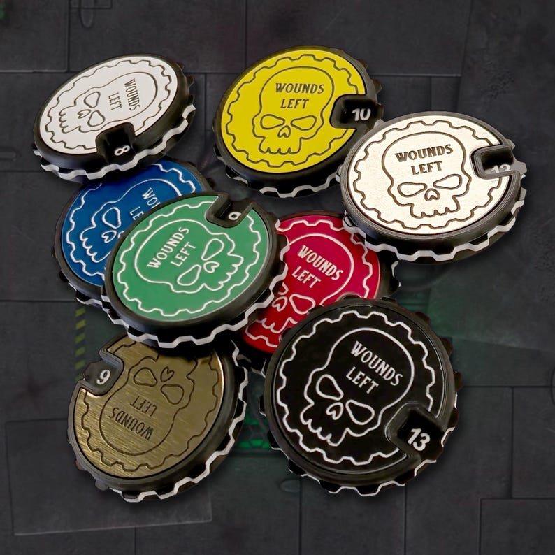 May include: A set of eight round, multi-colored, plastic wound counters with a skull graphic and the text "Wounds Left". The counters are numbered 8, 9, 10, 12, and 13.