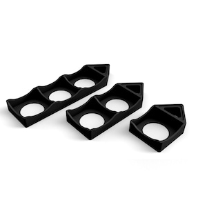 May include: Three black, geometric objects with holes are displayed against a white backdrop. Two have three holes, and one has a single hole. The objects have a triangular shape on one end.