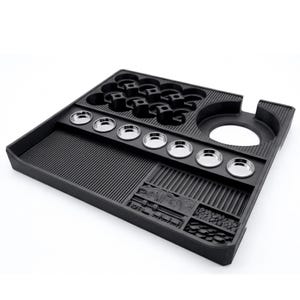 May include: A black, multi-compartment tray with various shaped recesses. It features a series of small, round, silver-colored metal containers and several cup-shaped holders. The tray has a textured surface and a large circular opening on the side.
