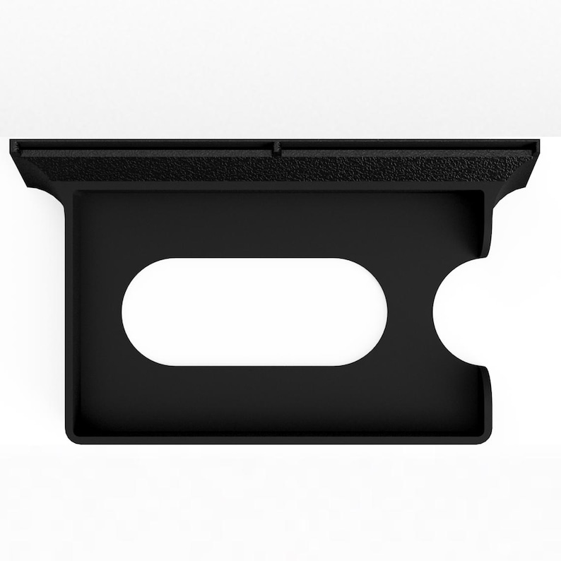 May include: A matte black wall-mounted holder featuring a textured top edge, a rectangular frame with a central horizontal oval cutout, and a semi-circular notch on the right side, designed for organizing small items or holding specific accessories.