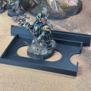 May include: A painted miniature figure of a green-skinned orc warrior with a yellow and black striped power claw, holding a large mechanical axe. A small green creature sits on the orc's shoulder. The base features a plaque reading BIG GIT BORIS.
