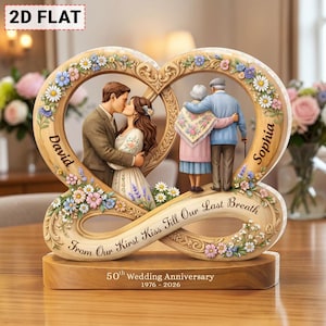 Puede incluir: Una escultura de aniversario de madera con dos marcos entrelazados en forma de corazón. Uno representa a una pareja joven besándose, el otro a una pareja mayor abrazándose. La base dice "50th Wedding Anniversary 1976-2026".