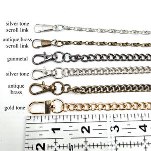 May include: A selection of metal chain straps in various colors, including silver, antique brass, gunmetal, and gold. Each chain is attached to a clasp. The image includes a ruler for size reference.