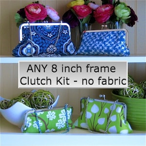 May include: Three different fabric clutch bags with silver frames and chains. The bags are on a white shelf with a sign that reads "ANY 8 inch frame Clutch Kit - no fabric".