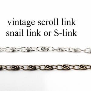 May include: Two chains with a scroll link design, also known as snail link or S-link. One chain is silver-colored, and the other is a bronze tone. The text "vintage scroll link snail link or S-link" is above the chains.